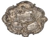 an antique silver plate with a picture of a castle on it