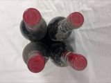 four bottles of wine sitting on a white surface