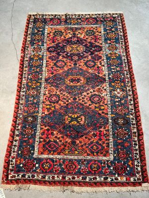 an antique persian rug with red and blue colors
