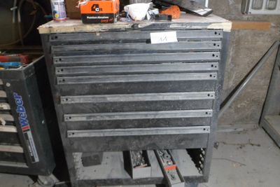 a tool cabinet with tools on top of it in a garage