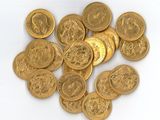 une pile de pièces d'or posée sur une surface blanche