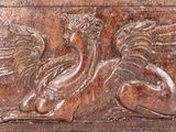 carvings of a bird with wings on a wooden panel