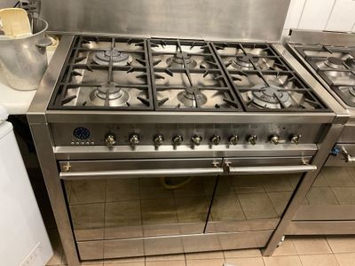 two stoves that are in a kitchen with pots on the counter