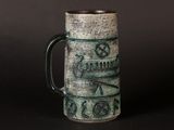 a green mug with writing on it sitting on a table