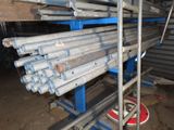 many steel pipes stacked on a rack in a warehouse