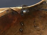 a large metal bowl with a bird on top of it
