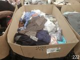 une boîte pleine de vêtements posée sur le sol