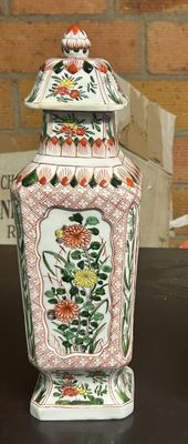 deux vases posés sur une table, avec un mur de briques en arrière-plan