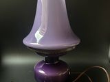 a purple lamp sitting on top of a table next to a laptop computer