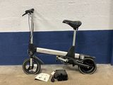 une petite trottinette électrique posée contre un mur bleu et blanc
