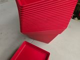 de nombreux récipients en plastique rouge posés sur une table