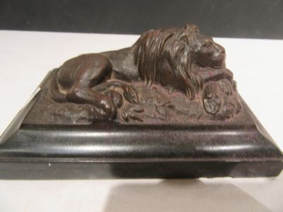 a statue of a lion laying on top of a base