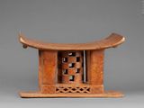 an old wooden stool with a carved design on top of it