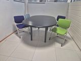 a table and chairs in a room with a white wall
