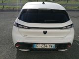 the rear end of a white car parked in a parking lot