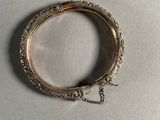 a close up of a silver bracelet with a chain around it