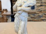 a white statue of a woman holding a baby on a table