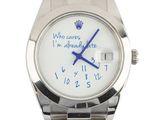 a wrist watch with a message written on it