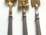trois cuillères et une spatule sont posées sur une surface blanche