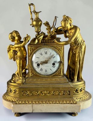a gold clock with a statue of angels on top of it
