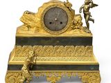 a gold clock sitting on top of a black and gold table