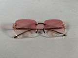 a close up of a pair of pink sunglasses on a white surface