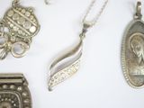 a lot of silver jewelry on a white surface