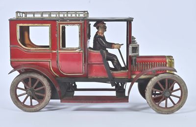 a red toy car with a man sitting in the driver ' s seat