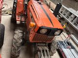 un tracteur rouge garé à côté d'un camion rouge dans un garage