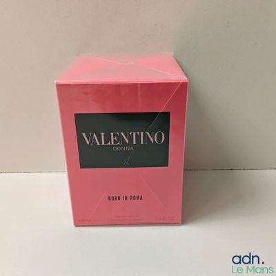 a pink box of perfume sitting on top of a white table