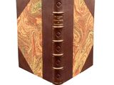 an old book with a brown cover and a paisley design