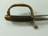 a close up of a sword on a white surface
