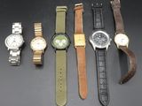 Plusieurs montres différentes sont alignées sur une surface noire
