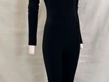 Le mannequin porte un body noir à col montant et à manches longues.
