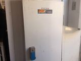 a white refrigerator sitting in the corner of a room