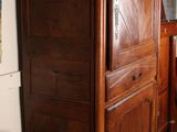 a large wooden cabinet in a room with pictures on the wall