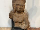 an image of a statue of a person sitting on a rock