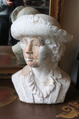a bust of a woman with a hat on a table