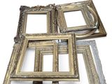 several antique picture frames are stacked on top of each other