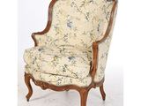 une chaise dont le dossier est recouvert d'un tissu à motifs floraux et dont la structure est en bois