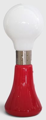 a red and white table lamp on a white surface