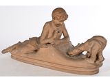 statue représentant un garçon avec un chien et un chat sur un bateau