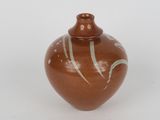 a brown vase with white designs on it on a white surface