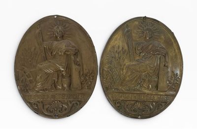 deux médaillons en bronze représentant une femme et un homme dans un jardin