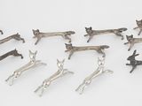 six paires de figurines anciennes en argent représentant des cerfs, posées sur un fond blanc