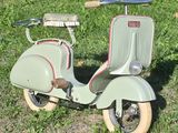a scooter that is sitting in the grass on the ground