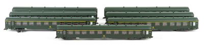 three green train cars sitting next to each other on a white surface
