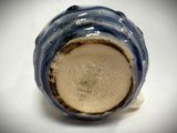 a close up of a blue and white vase on a table
