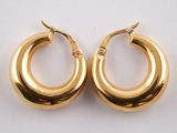 two pairs of gold hoop earrings on a white surface