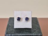 une paire de boucles d'oreilles en saphir bleu posées sur un bloc de marbre